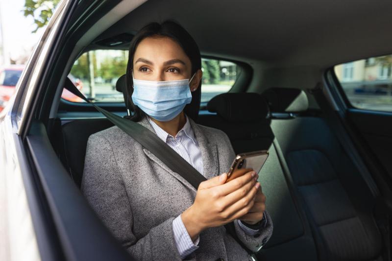 Businesswoman with medical mask smartphone car